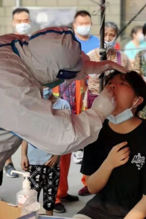 直击武汉核酸检测现场，市民为全身汗湿的医护人员送水
