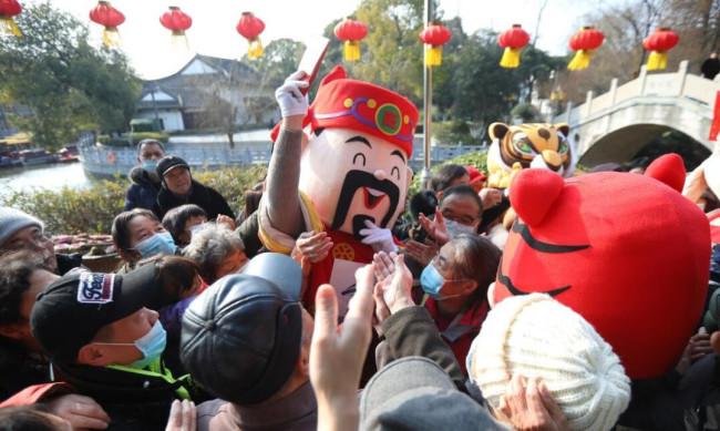 2022年2月5日，江苏南京，“财神爷”现身城南白鹭洲公园，向民众发放红包，快乐过大年。农历正月初五，我国民间有“迎财神”的习俗，各地开展了“迎财神”民俗活动。